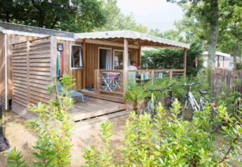 Casa mobile in legno premium al Flower Camping La Canadienne in Francia, con terrazza e biciclette.