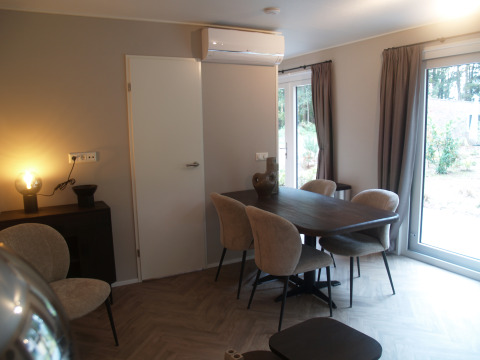 Sala da pranzo moderna al Groeneborg lodge, Vakantiepark De Wiltzangh, con tavolo, sedie e grandi finestre.