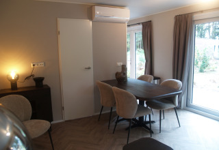 Sala da pranzo moderna al Groeneborg lodge, Vakantiepark De Wiltzangh, con tavolo, sedie e grandi finestre.