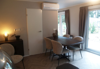 Moderne spisestue på Groeneborg lodge ved Vakantiepark De Wiltzangh, med træbord og store vinduer.