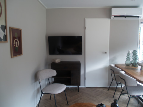 Moderne woonkamer in Groeneborg lodge met televisie, eettafel en airco in Vakantiepark De Wiltzangh.