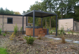 Buitenhottub met afdak voor moderne lodges in een groene omgeving bij Groeneborg lodge.