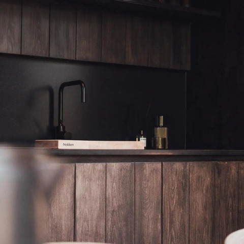 Zona de fregadero de cocina de madera oscura en la Nokken Forest Cabin, Wilsumer Berge, Alemania.