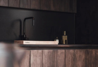 Moderne, donkerhouten keuken met wasbak in Nokken Forest Cabin, Wilsumer Berge, Duitsland.