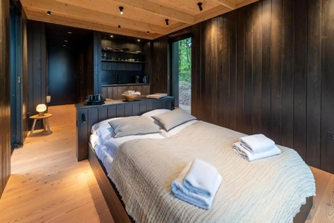 Dormitorio de madera en la Nokken Forest Cabin en Wilsumer Berge, Alemania, con decoración moderna y acogedora.