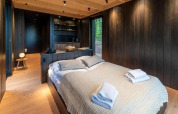 Schlafzimmer mit Holzausstattung in der Nokken Forest Cabin bei Wilsumer Berge, Deutschland, modern gestaltet.