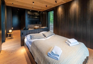 Dormitorio de madera en la Nokken Forest Cabin en Wilsumer Berge, Alemania, con decoración moderna y acogedora.