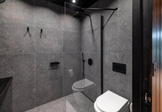 Baño moderno en la Nokken Forest Cabin con ducha y sanitario en Wilsumer Berge, Alemania.