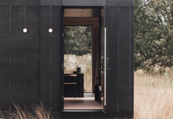 Entrada a la Nokken Forest Cabin en Wilsumer Berge, Alemania, rodeada de naturaleza y diseño moderno.