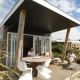 Familie nyder afslapning på terrassen ved Beach Loft + Wellness på Camping Zonneweelde, Holland