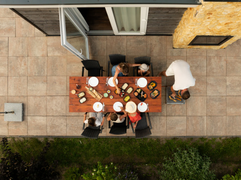 Luchtfoto van een gezin dat buiten eet aan een houten tafel bij Resort Mooi Bemelen in Nederland.