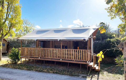Glamping Lodge PREMIUM safaritelte med overdækket veranda på Campingplads Le Val de Cesse i Frankrig.