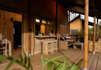 Terrazza in legno con salotto e bar nella tenda safari Glamping Lodge PREMIUM, Le Val de Cesse, Francia.