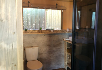 Baño en una tienda safari Glamping Lodge PREMIUM en el camping Le Val de Cesse, Francia, con comodidades modernas.