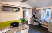 Living and kitchen area of an accessible Stacaravan Confort at Camping Demoiselles Plage, France.