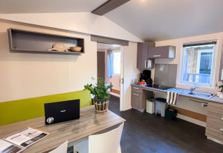 Woon- en keukenhoek van een toegankelijke Stacaravan Confort op Camping Demoiselles Plage, Frankrijk.