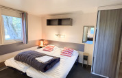 Accessible bedroom in Stacaravan Confort at Camping Demoiselles Plage, France, with a double bed.