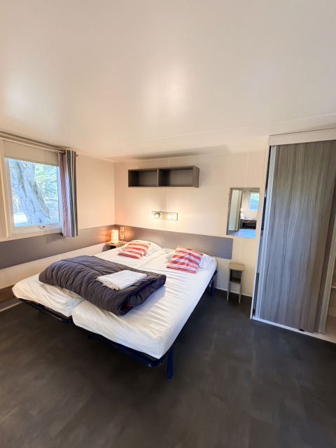 Toegankelijke slaapkamer in Stacaravan Confort, Camping Demoiselles Plage, Frankrijk, met dubbel bed.