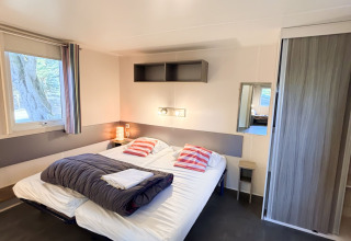 Toegankelijke slaapkamer in Stacaravan Confort, Camping Demoiselles Plage, Frankrijk, met dubbel bed.