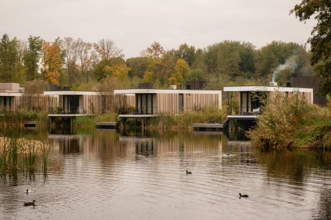 Moderne tiny houses aan het meer in Resort de Parel, Nederland, omgeven door water en natuur.