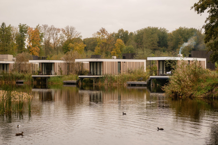 Moderne Tiny Houses am Wasser im Resort de Parel in den Niederlanden, umgeben von Natur.