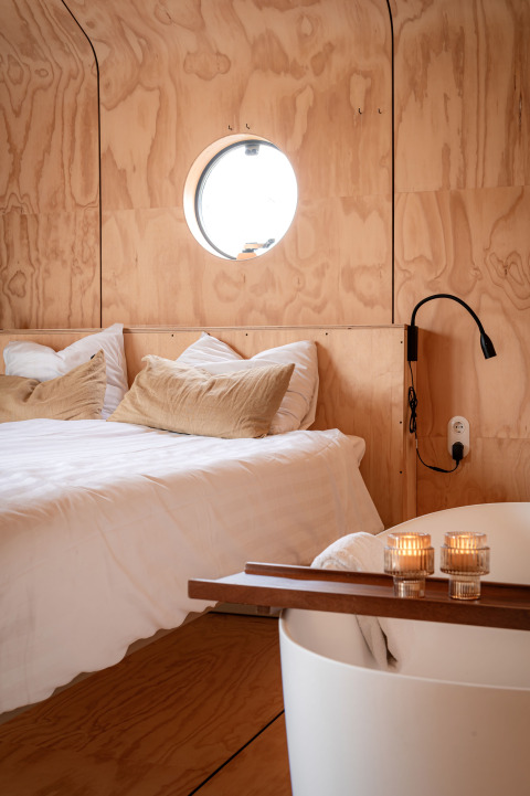 Wrap house lodge con sauna e vasca da bagno al Resort de Parel nei Paesi Bassi; interni in legno chiaro.