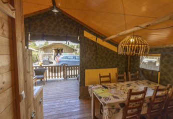 Interno di una Safaritent Sunset con tavolo da pranzo, bagno privato e aria condizionata a Camping Polari, Croazia.