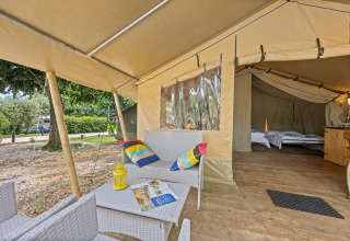 Cozy lounge and sleeping area inside the Safaritent Harmony safari tent with nature just outside.