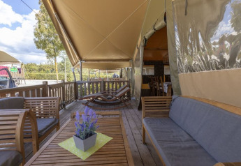 Coin salon extérieur d'une Safaritent Sunset au Camping Valkanela en Croatie, avec meubles en bois et plantes.