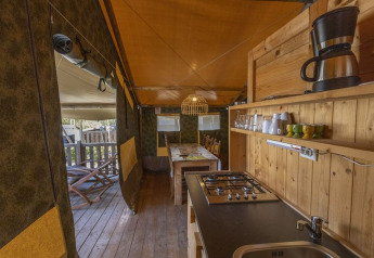 Interieur van een safaritent met keuken, eettafel en houten details op Camping Polari in Kroatië.