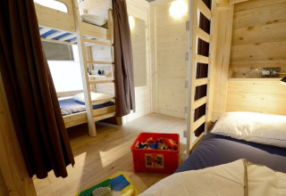 Binnenzicht van een safaritent met stapelbedden en speelgoed op Camping Polari in Kroatië, privébadkamer.