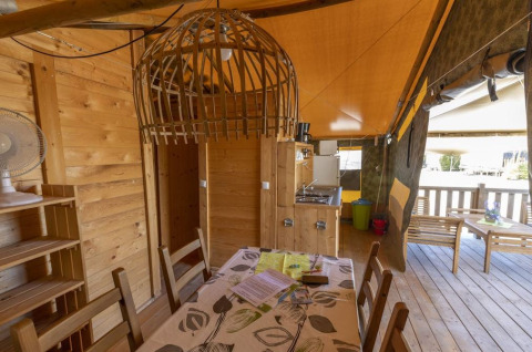 Indretning af Safaritent Sunset med trævægge, spisebord og terrasse på Camping Valkanela i Kroatien.