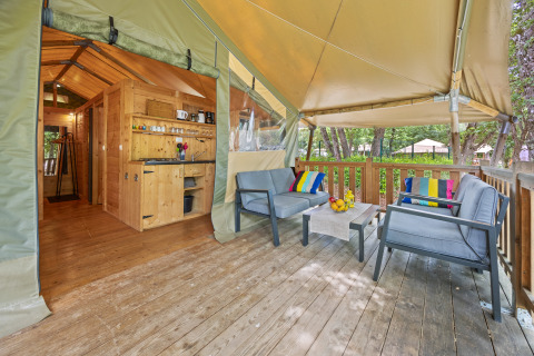 Terraza con sillas modernas y cojines coloridos en una tienda safari en Camping Valkanela, Croacia.