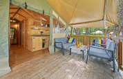 Veranda accogliente con poltrone moderne e cuscini colorati in una tenda safari al Camping Valkanela, Croazia.