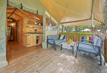 Terrasse accueillante avec fauteuils modernes et coussins colorés dans une tente safari, Camping Valkanela, Croatie.