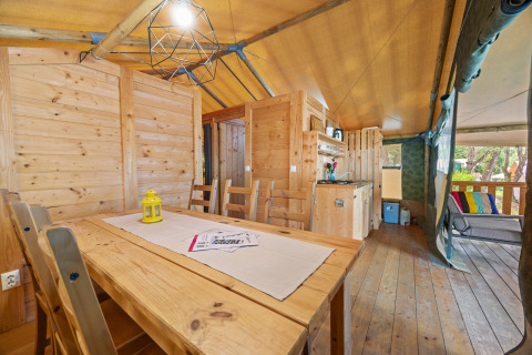 Binnenzicht van Safaritent Sunset op Camping Valkanela in Kroatië met houten inrichting en terras.