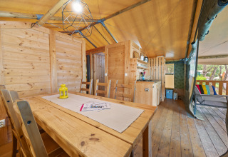 Binnenzicht van Safaritent Sunset op Camping Valkanela in Kroatië met houten inrichting en terras.