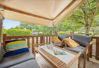 Espace détente sur la terrasse de la Safaritent Relax avec coussins confortables et vue sur la nature.