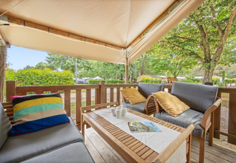 Zona relax sulla terrazza della Safaritent Relax con comodi divani, cuscini e vista sulla natura.