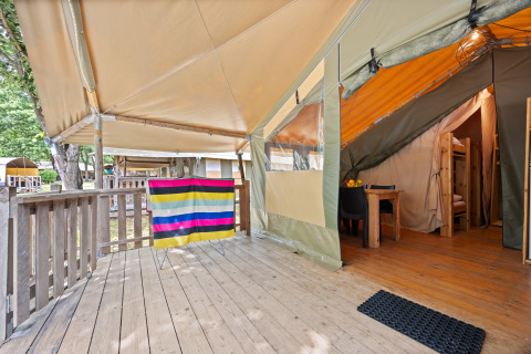 Houten buitenterras en ingang van de Safaritent Relax met kleurrijke doek en gezellige inrichting.