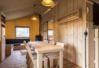 Intérieur de la Safaritent Bella Lodge au Camping Valkanela en Croatie avec salle à manger en bois.