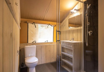 Bathroom inside Safaritent Bella Lodge at Camping Valkanela, Croatia, with shower, toilet and sink.