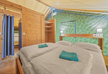 Interno della Safaritent Sunset con bagno privato e aria condizionata al Camping Polari in Croazia.