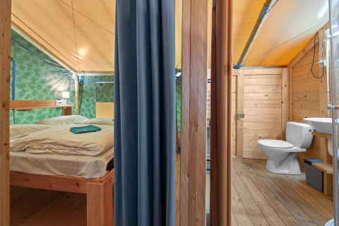 Interno della Safaritent Sunset con bagno privato e aria condizionata al Camping Polari in Croazia.