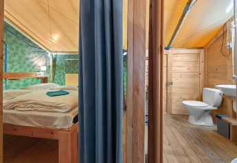 Interno della Safaritent Sunset con bagno privato e aria condizionata al Camping Polari in Croazia.
