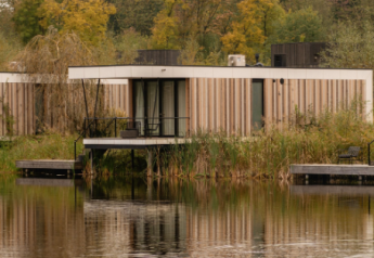 Moderne Waterlodge Sauna bij Resort de Parel in Nederland, aan het water en omgeven door herfstkleurige bomen.