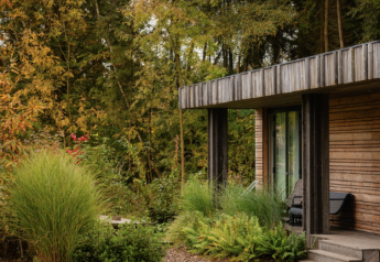 Lodge en bois moderne au Resort de Parel, Pays-Bas, entourée de verdure luxuriante et d’arbres.