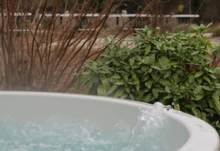 Bain à remous extérieur à la Villa Roof Terrace + Hot tub au Resort de Parel, entouré de verdure.