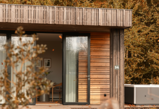 Lodge en bois moderne avec jacuzzi privé et grandes baies vitrées, Resort de Parel, Pays-Bas, en forêt.