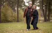 Couple walking on the grass at Holiday villa Amalia 2 with sauna and hot tub at Hofparken Wiltershaar, Netherlands.
